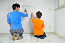 Frau und Kind streichen Wand - Malerarbeiten im Teamwork by Matthias Hauser