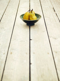 green bowl filled with yellow pears by Priska  Wettstein