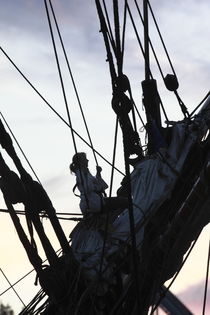 Young woman climbing in the rigging of a tall ship at dusk von Intensivelight Panorama-Edition