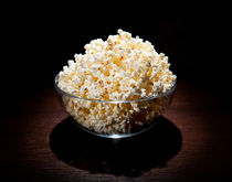 crunchy popcorn in glass bowl by Arletta Cwalina