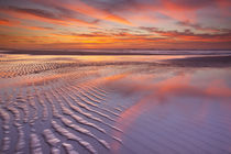 Beautiful sunset and reflections on the beach at low tide von Sara Winter