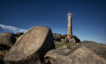 Lighthouse behind rocks at Cabo Polonio by Diana C. Bernardi