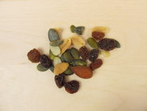 Nüsse, Kerne und Rosinen auf einem Holzhintergrund von Heike Rau