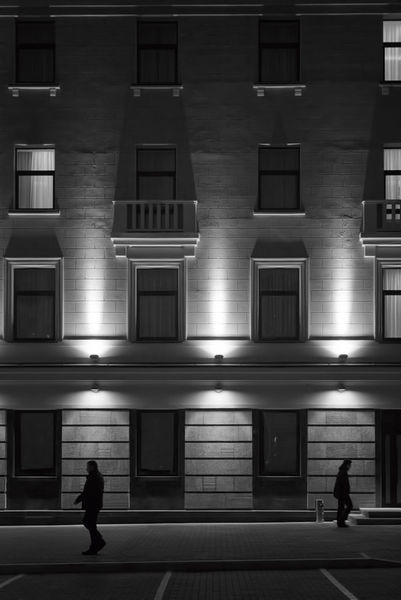 Exterior-building-facade-at-night-with-people-walking
