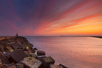 Sunset over harbour entrance at sea in IJmuiden, The Netherlands by Sara Winter