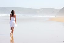 Beautiful young woman walking at the beach by nilaya