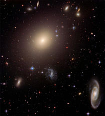 Elliptical Galaxy and its Host Galaxy Cluster. by Stocktrek Images
