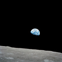 Earth rising above the lunar horizon. by Stocktrek Images
