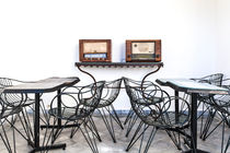 Ein Arrangement von Tischen und Stühlen und zwei alten Radios von Gina Koch