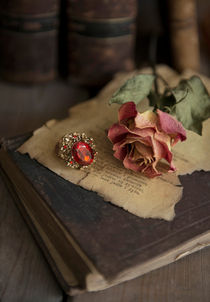 Still life with old books, dried rose and big ring von Jarek Blaminsky