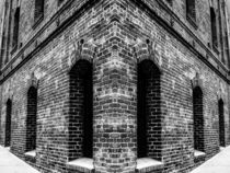 old brick building with windows in black and white by timla