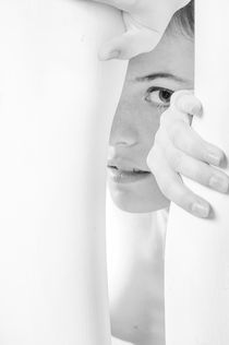 yound woman peeking and reaching through a bright gap by Jessy Libik