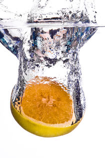Grapefruit falls into water with big splash on white background by Sharon Yanai