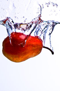'Pear falls into water with a splash on white background' by Sharon Yanai