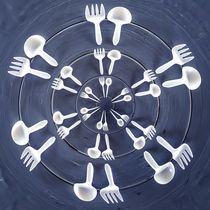 forks and spoons on the wooden table in circle pattern by timla