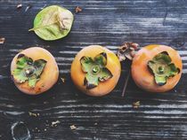 persimmons on the wooden table von timla