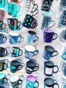 colorful mugs hanging on the white wall von timla