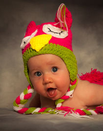 Happy baby in a woollen hat by Leighton Collins