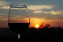 Rotweinglas vor einem Sonnenuntergang von stephiii