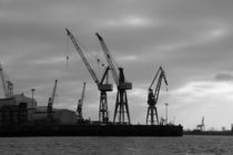 Dock with a container ship and many cranes in the harbour of Hamburg by stephiii