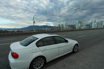 White car in front of the Skyline of Vancouver by stephiii
