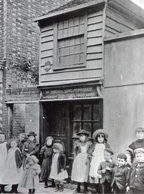Children outside John Pounds's workshop by English Photographer