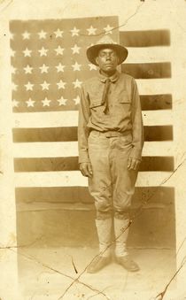 World War I soldier with American flag in background by American Photographer