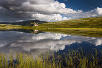 Huts on lake in landscape of Norway by Bastian Linder