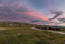 Huts in landscape of Norway during sunset von Bastian Linder