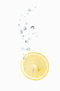 Lemon in water with air bubbles by Bastian Linder