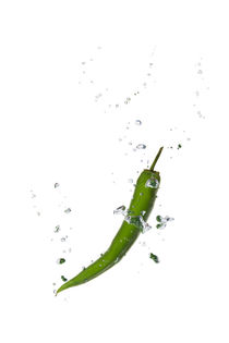 Green chili in water with air bubbles by Bastian Linder