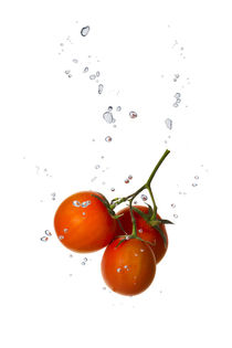 Cherry tomato in water with air bubbles by Bastian Linder
