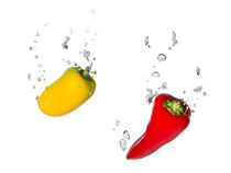 Yellow and red capsicum in water with air bubbles by Bastian Linder