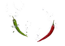 Green and red chili in water with air bubbles by Bastian Linder