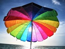 bunter Sonnenschirm am Strand von assy
