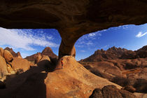 Boy under natural rock arch at Spitzkoppe, and Pondok Mounta... by Danita Delimont