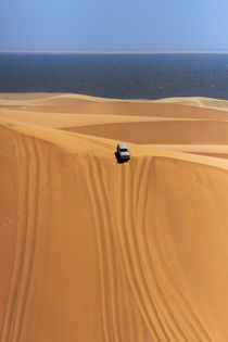 Four wheel drive descending a huge sand dune on a Sandwich H... by Danita Delimont