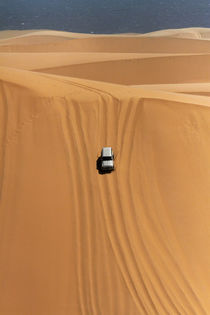 Four wheel drive descending a huge sand dune on a Sandwich H... by Danita Delimont