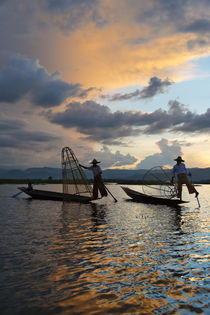 Intha fisherman rowing boat with leg at sunset on Inle Lake,... by Danita Delimont