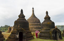 Monk holding red umbrella with Andaw-thein Temple, Mrauk-U, ... von Danita Delimont