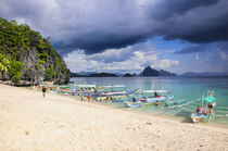 Outrigger boats before a storm anchoring on a sandy beach in... von Danita Delimont