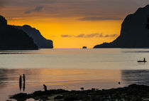 Silhouette of boys fishing at sunset in the bay of El Nido, ... by Danita Delimont