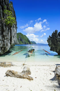 Outrigger boat on a little white beach and Clear water in th... von Danita Delimont