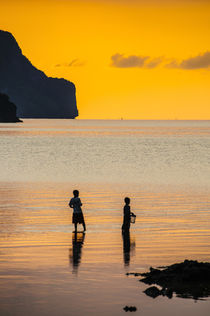 Silhouette of boys fishing at sunset in the bay of El Nido, ... von Danita Delimont