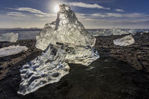 Scattered ice from icebergs on black sand beach at Joklusarl... by Danita Delimont