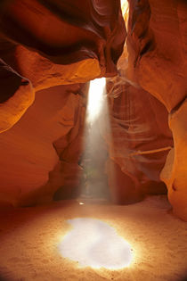 Navajo Nation, shaft of light and eroded sandstone formation... by Danita Delimont