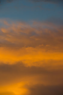 Clouds reflecting the orange sunset colors against the blue ... by Danita Delimont