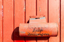 Red mailbox on a red wall von domi