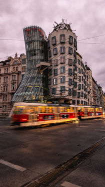 Red tram under a Dancing House by Tomas Gregor