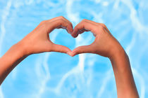 Two little hands forming heart over swimming pool von Silvia Eder